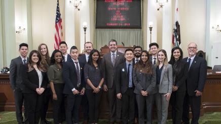 Assemblymember Wood on Assembly Floor with a Visiting Group of Dental Students in front of dais